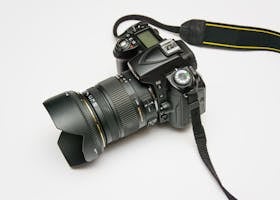 Close-up of a DSLR camera with a lens and strap, ideal for photography equipment themes.